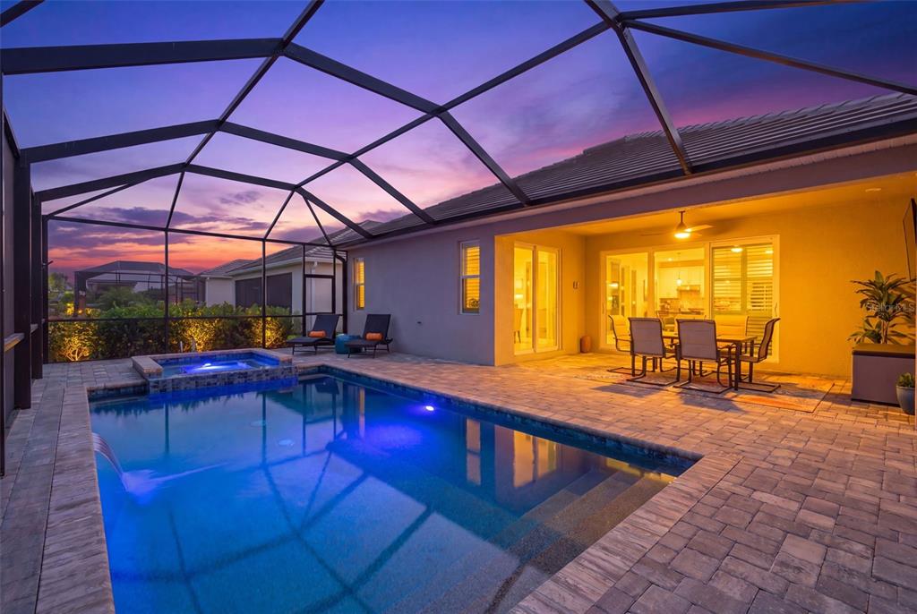 A screened-in patio features a swimming pool, a hot tub, and an outdoor dining area — 17260 JADESTONE COURT, VENICE, FL
