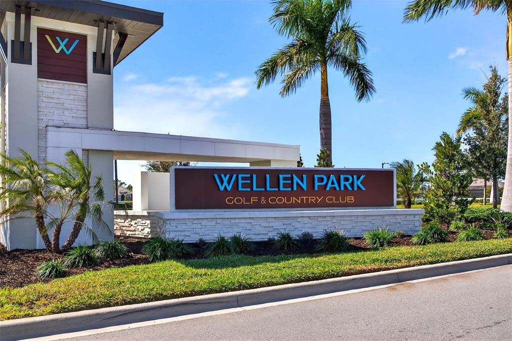A sign for Wellen Park Golf & Country Club stands in front of a modern entrance — 17260 JADESTONE COURT, VENICE, FL