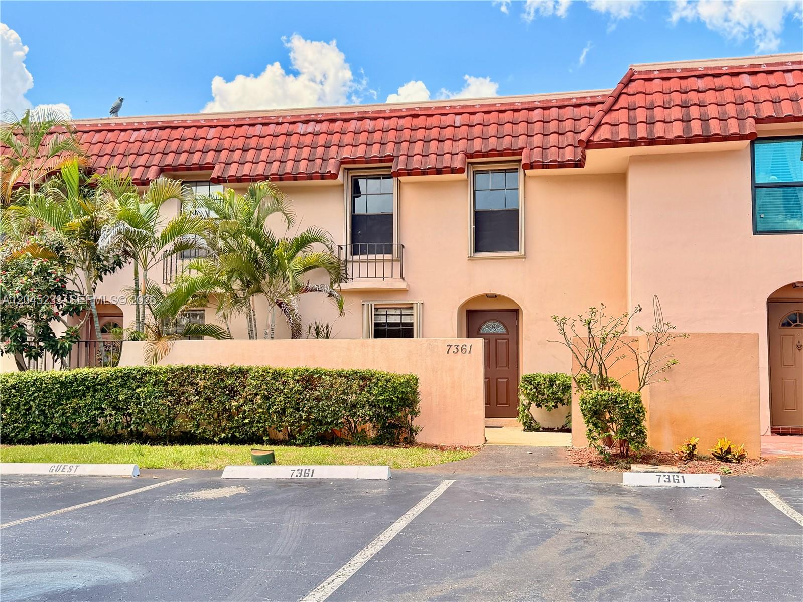 A two-story peach-colored townhouse features a red tile roof and a private front courtyard — 7361 SW 26th Ct # 84, Davie FL 33314, DAVIE, FL