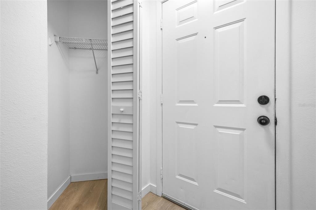 A white front door sits next to an open closet with a wire shelf — 3038 PARKWAY BOULEVARD UNIT 306, KISSIMMEE, FL