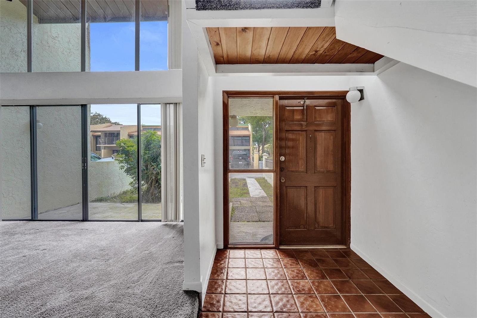 An entryway features a wooden door, tiled floor, and a view of the exterior — 750 E Coco Plum Circle # 2, Plantation FL 33324, PLANTATION, FL