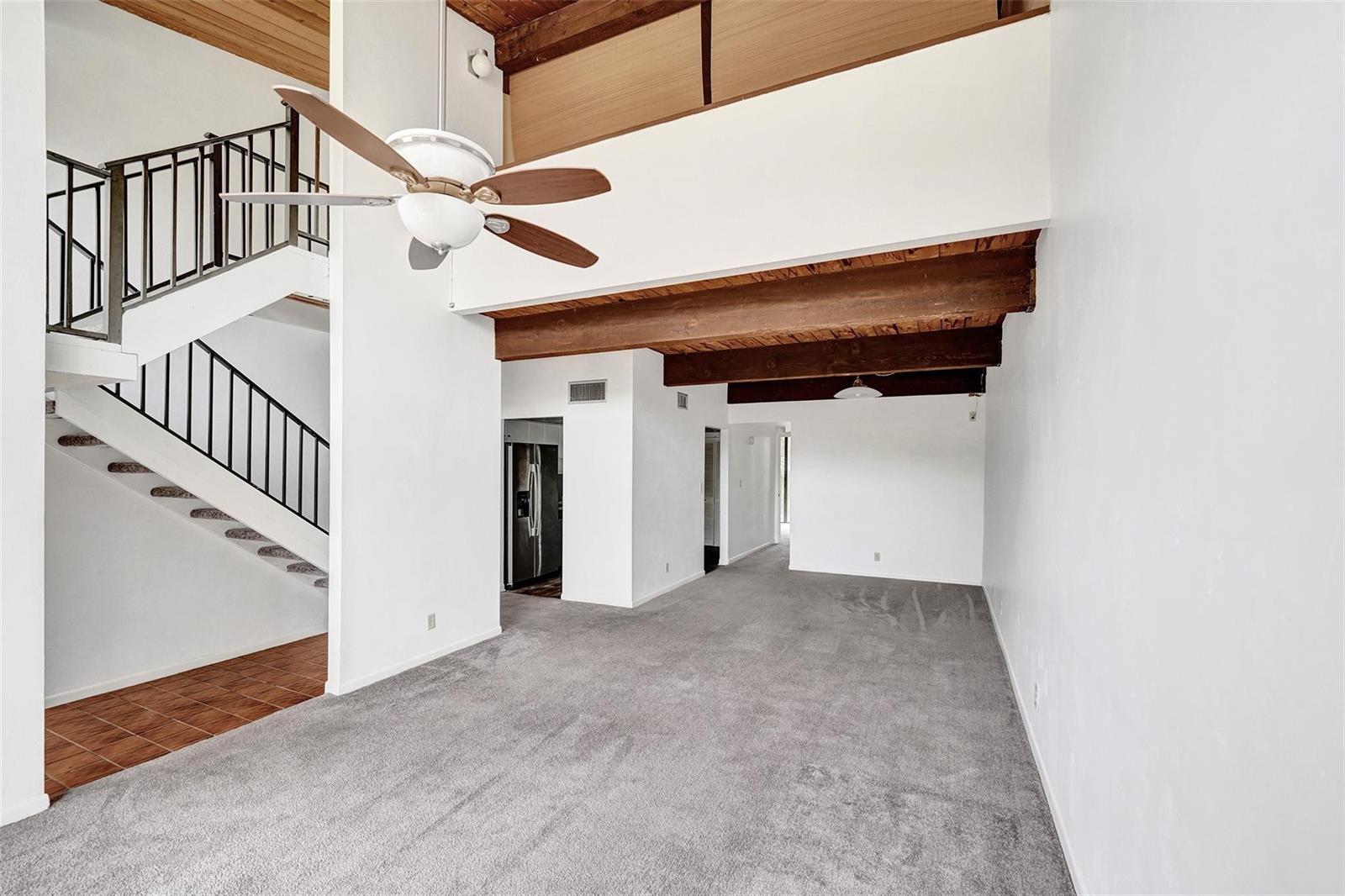 A living room with gray carpet, a staircase, and exposed wooden ceiling beams — 750 E Coco Plum Circle # 2, Plantation FL 33324, PLANTATION, FL
