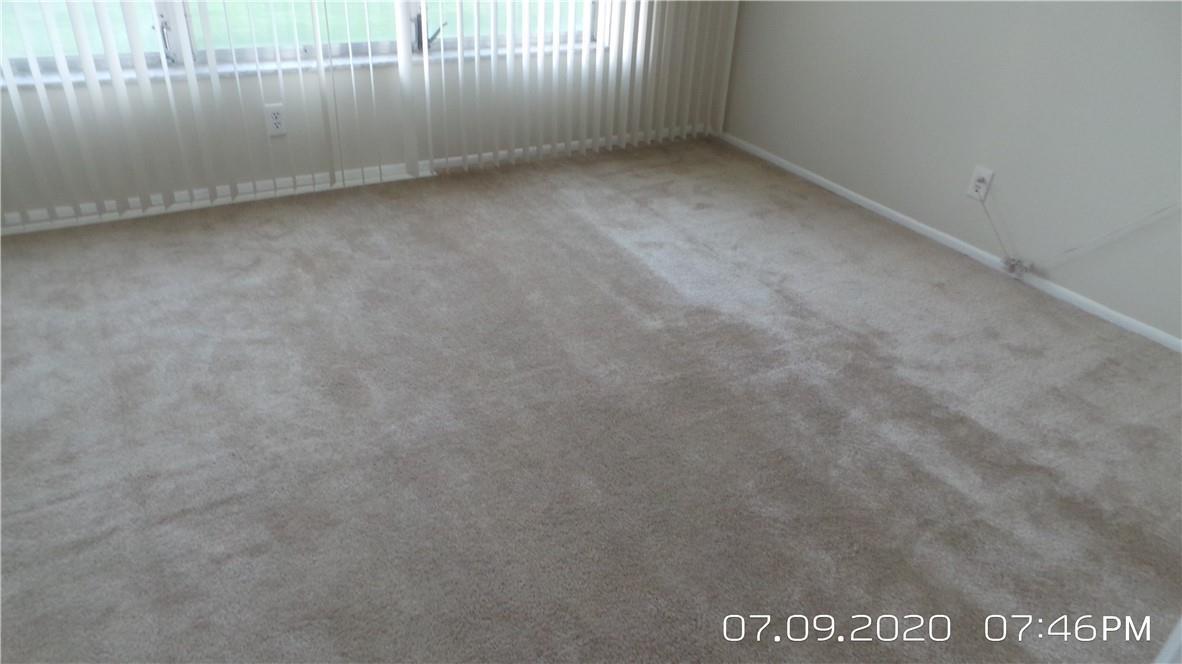An empty room features beige wall-to-wall carpeting and vertical blinds covering a large window — 2651 S Course Drive # 403, Pompano Beach FL 33069, POMPANO BEACH, FL