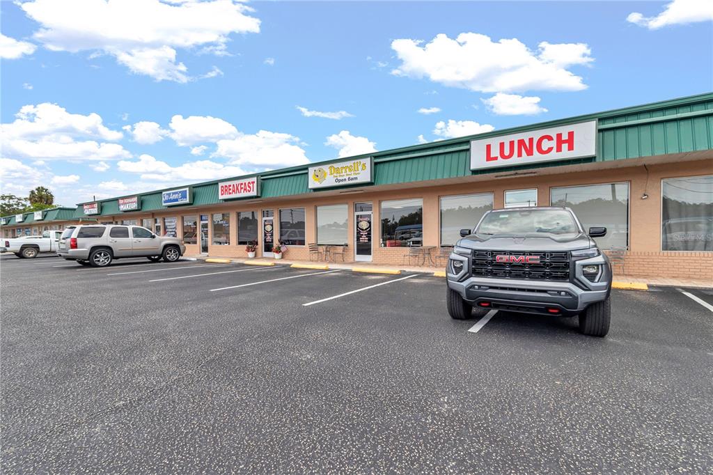 A gray GMC pickup truck is parked in front of a commercial strip mall — 963 N SUNCOAST BOULEVARD, CRYSTAL RIVER, FL