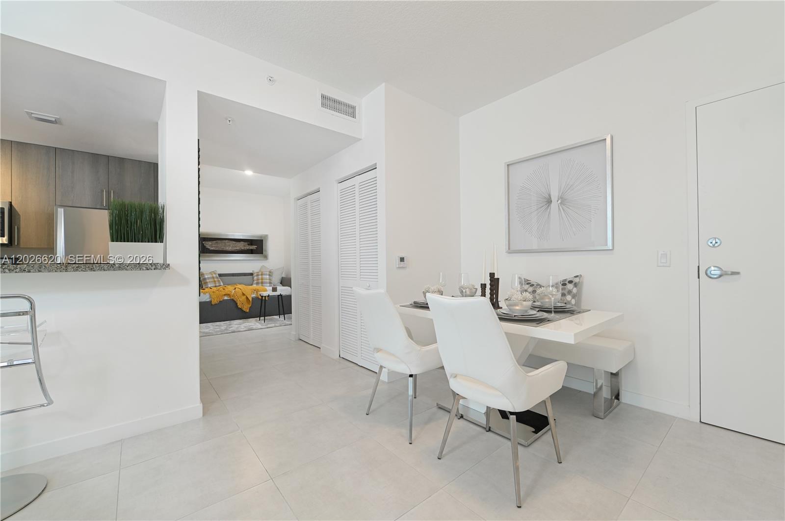 A dining area with a white table and chairs sits adjacent to a kitchen — 514 SW 22nd Ave # 405, Miami FL 33135, MIAMI, FL