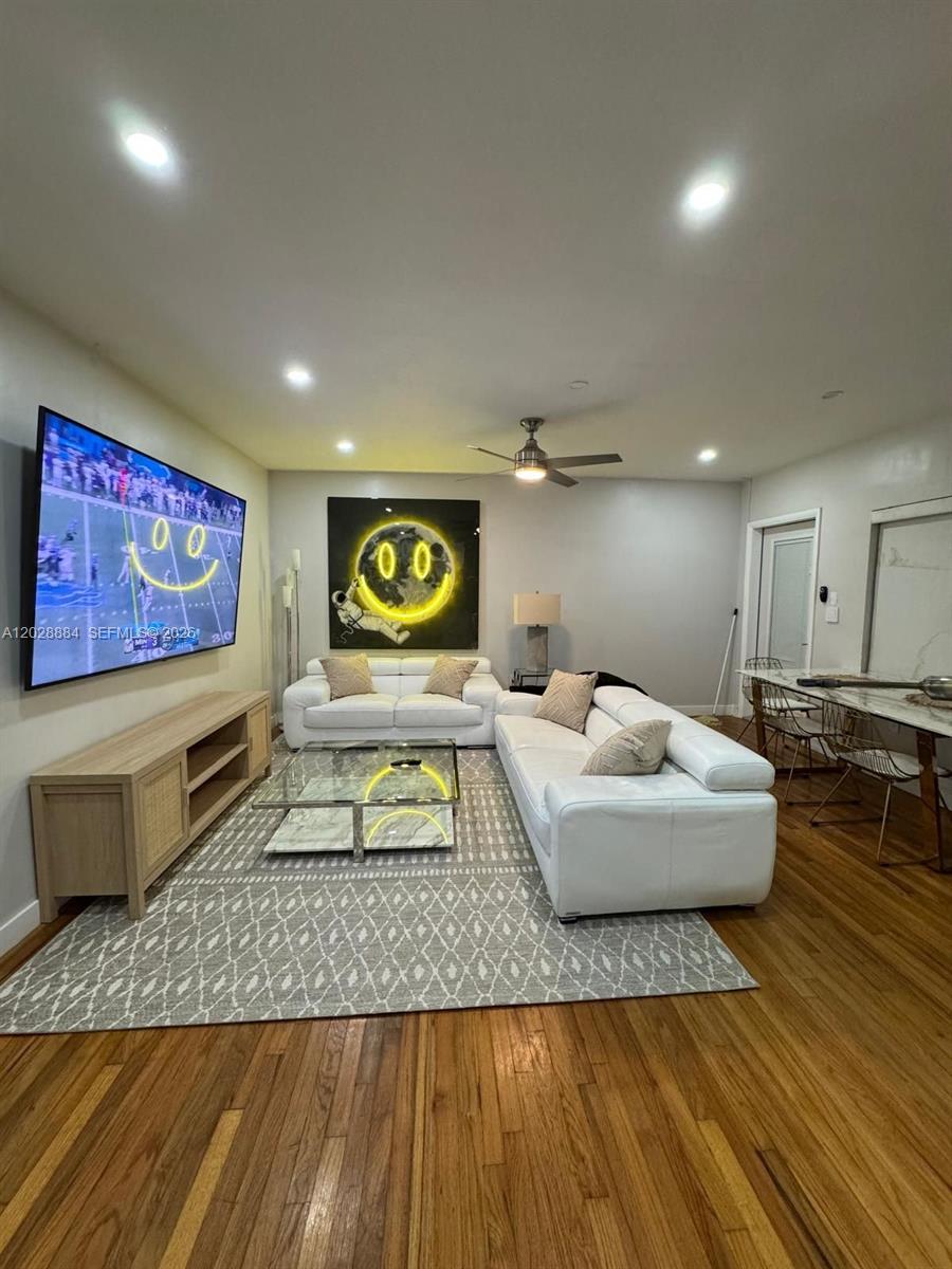 A living room features white sofas, a glass coffee table, and a large wall-mounted television — 101 Collins Ave # 3, Miami Beach FL 33139, MIAMI BEACH, FL