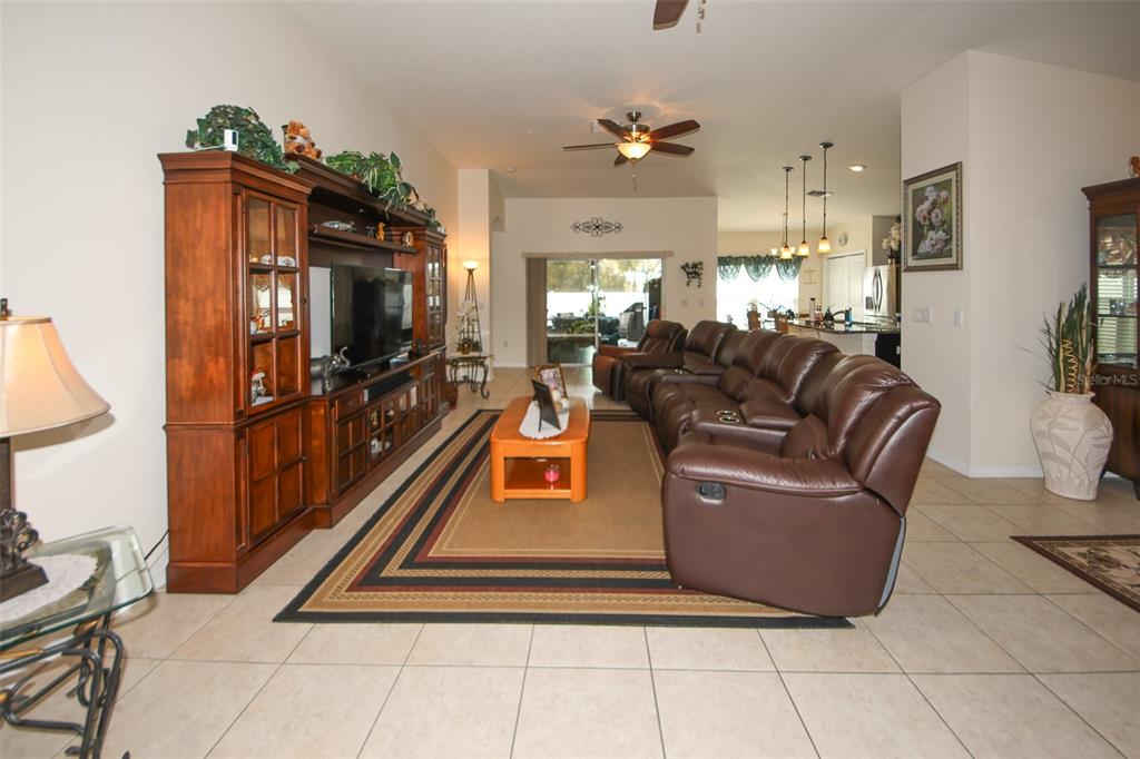 A living room features a large brown sectional sofa, an entertainment center, and tile flooring — 14148 FINSBURY DRIVE, SPRING HILL, FL