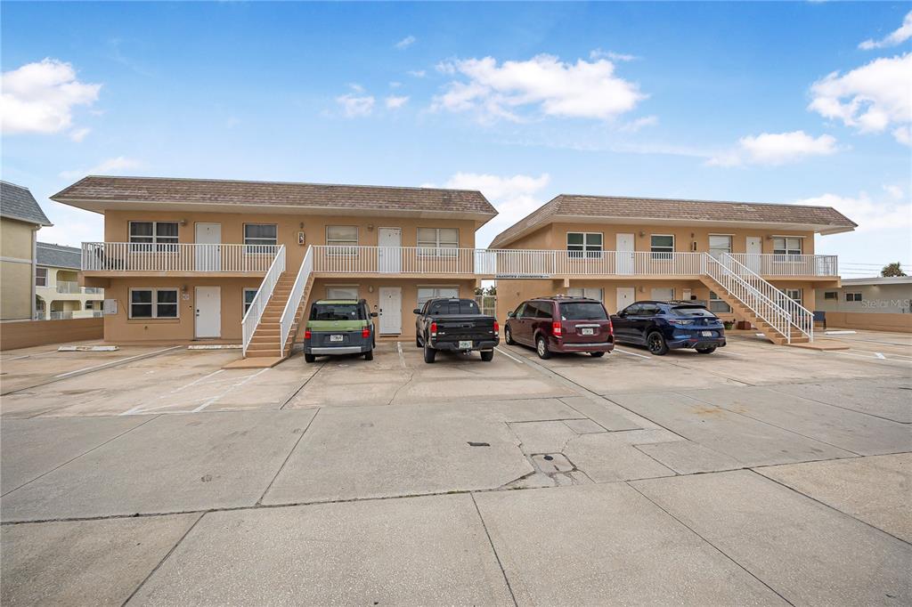 A two-story apartment building with exterior walkways, stairs, and a paved parking lot — 3724 S ATLANTIC AVENUE UNIT 30, DAYTONA BEACH, FL