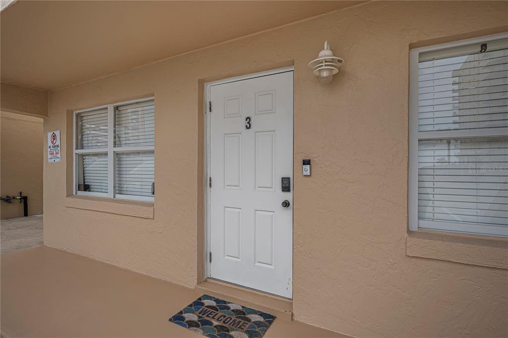 A white front door marked with the number three sits between two windows on a patio — 3724 S ATLANTIC AVENUE UNIT 30, DAYTONA BEACH, FL