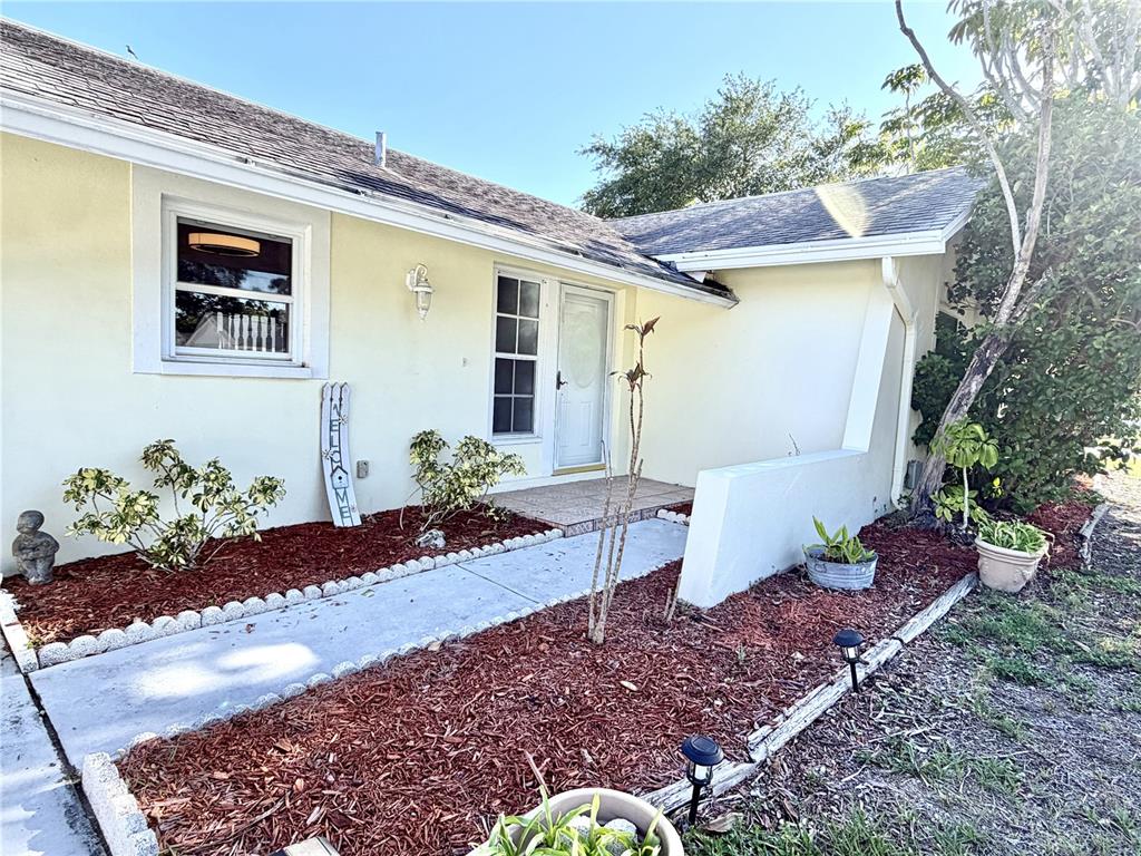 A pale yellow house exterior features a concrete walkway leading to a front entrance — 8212 101ST COURT, SEMINOLE, FL