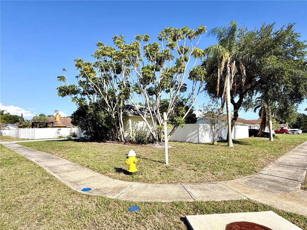 A yellow house sits behind a white fence with a fire hydrant in the yard — 8212 101ST COURT, SEMINOLE, FL