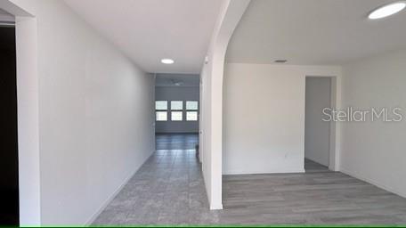 An interior view showing a hallway with tiled floors leading to a room with windows — 3879 SHORESIDE DRIVE, KISSIMMEE, FL