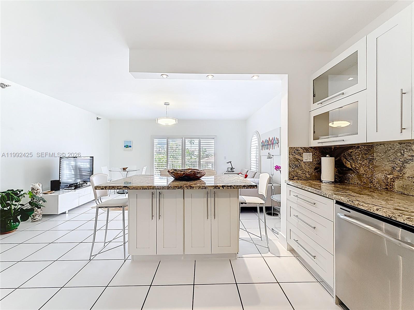 A bright entryway with white tile floors leads into an open-concept living area — 9008 Collins Ave # 303, Surfside FL 33154, SURFSIDE, FL