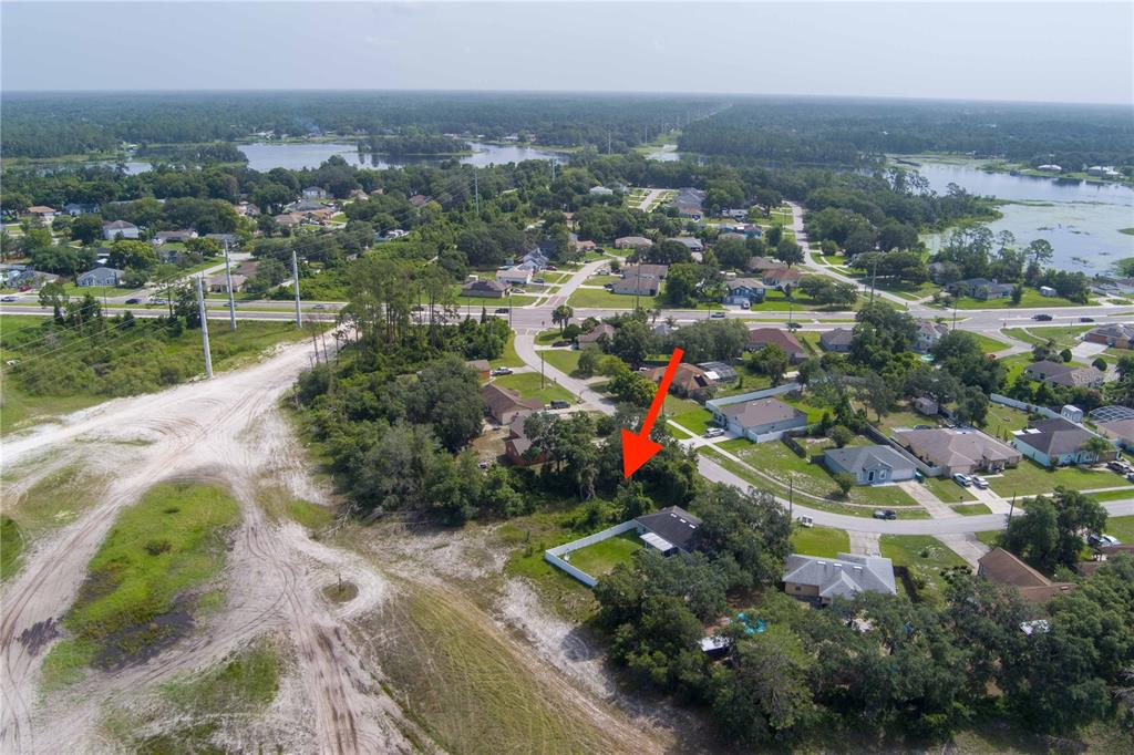 An aerial view shows a residential neighborhood with a red arrow pointing toward a house — 2599 HILLVIEW CIRCLE, DELTONA, FL