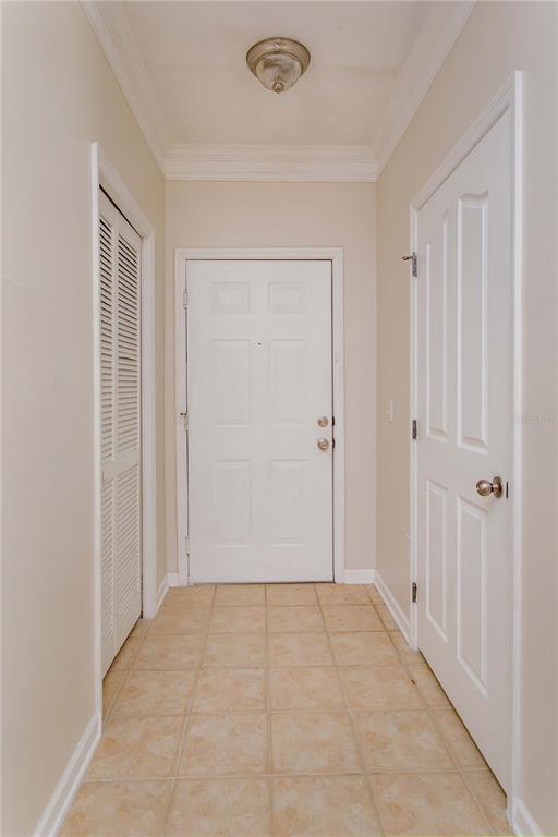 A hallway features a tiled floor, a white front door, and two interior doors — 12849 MADISON POINT CIRCLE UNIT 201, ORLANDO, FL