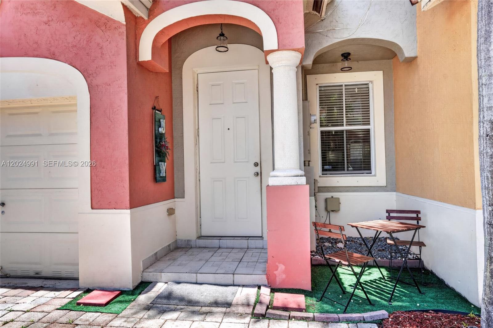 The exterior of a home features a white front door, a column, and a small patio — 16651 SW 79th Ter, Miami FL 33193, MIAMI, FL