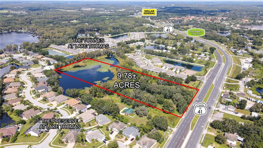 An aerial view shows a 9.78-acre plot of land adjacent to a highway and lake — 5927 LAND O LAKES BOULEVARD, LAND O LAKES, FL