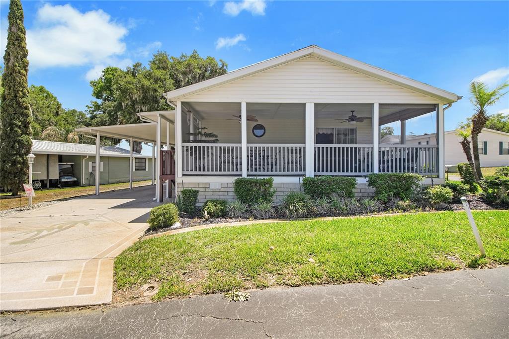 A single-story house with a screened-in porch, a carport, and a concrete driveway — 15 RIVERVIEW DRIVE, FRUITLAND PARK, FL