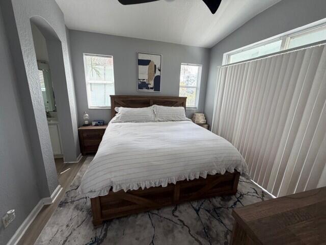 A bedroom features a wooden bed frame, gray walls, two windows, and a patterned rug — 3013 Laurel Ridge Circle, Riviera Beach FL 33404, RIVIERA BEACH, FL