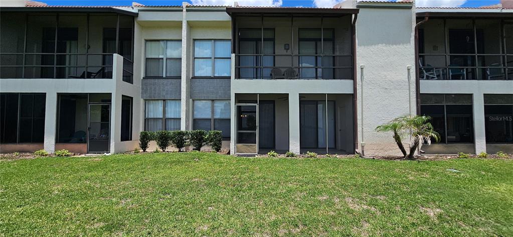 The exterior view shows a two-story apartment building with screened-in balconies and patios — 105 LAUREL COVE WAY UNIT 105, WINTER HAVEN, FL
