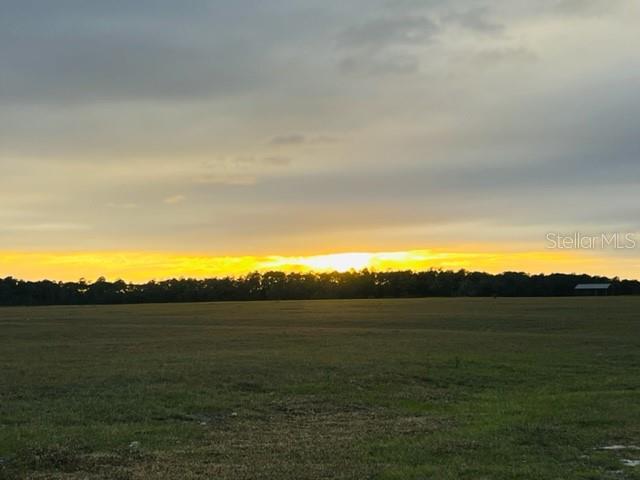 A wide, grassy field under a cloudy sky at sunset with a distant tree line — TBD SE 74TH LANE ROAD UNIT 8 & #9 West, OCKLAWAHA, FL