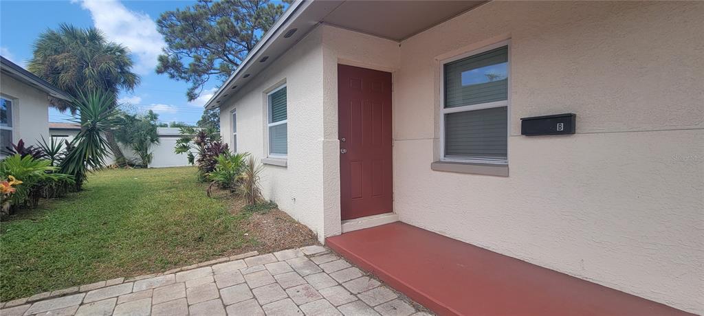 A red door and a matching painted porch entrance to a unit labeled B — 6625 S WEST SHORE BOULEVARD, TAMPA, FL