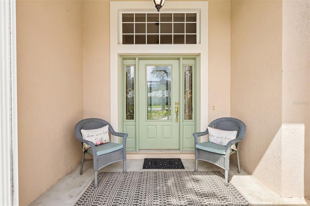 A living room features a fireplace, built-in shelving, a ceiling fan, and large windows — 20554 QUEEN ALEXANDRA DRIVE, LEESBURG, FL