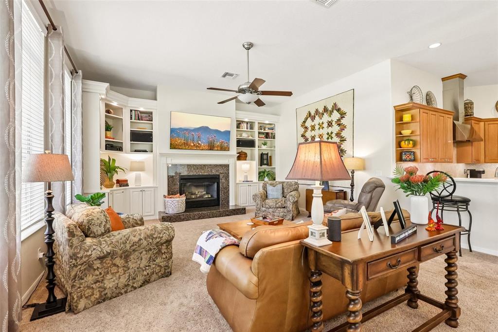 A kitchen features wood cabinets, granite countertops, a stainless steel range, and a center island — 20554 QUEEN ALEXANDRA DRIVE, LEESBURG, FL