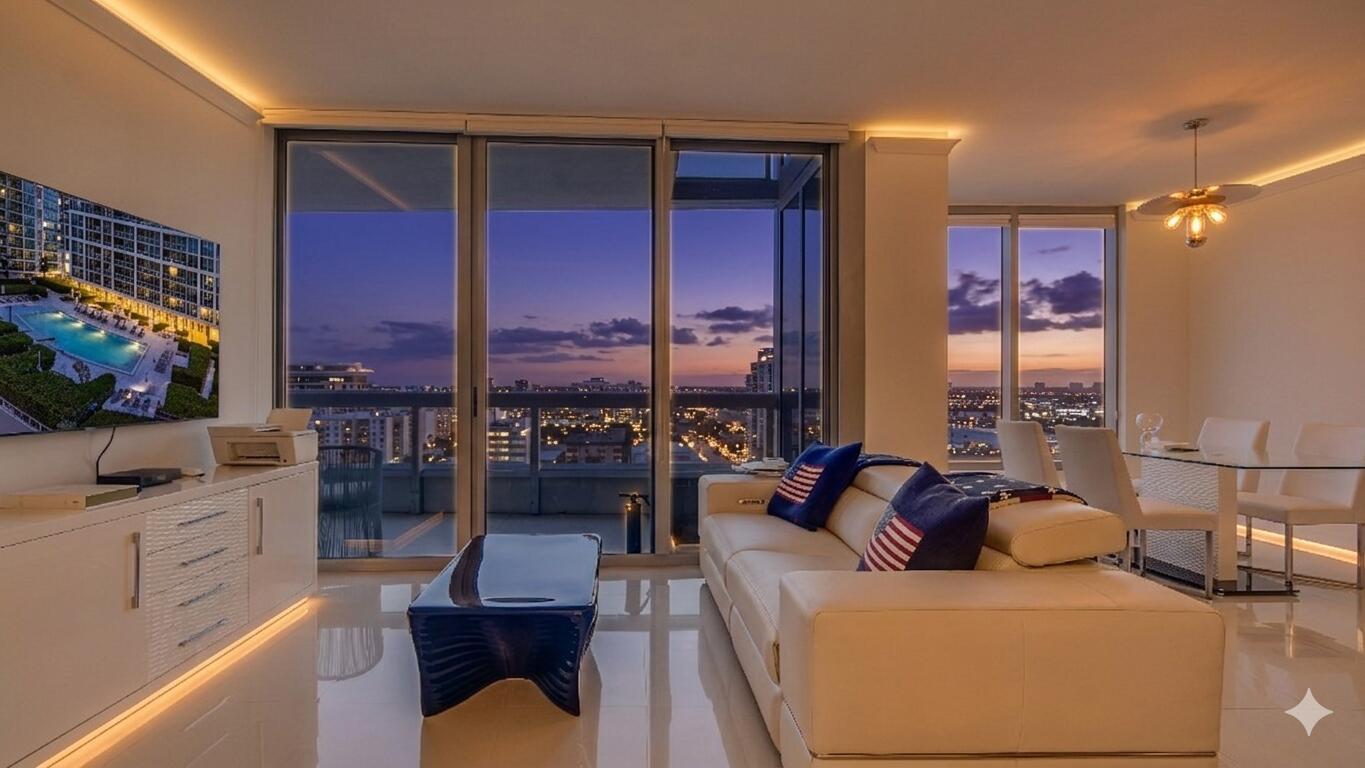 A modern living room with a white sofa, glass dining table, and floor-to-ceiling city views — 6899 Collins Avenue # 1203, Miami Beach FL 33141, MIAMI BEACH, FL