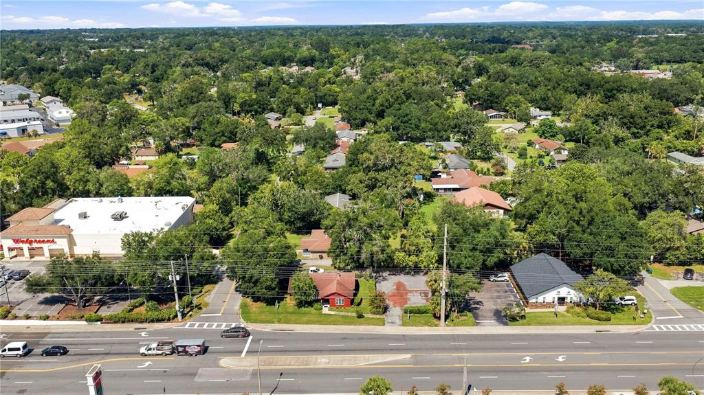 An aerial view shows a Walgreens store, a small red house, and a commercial building — 1112 NE 36TH AVENUE, OCALA, FL
