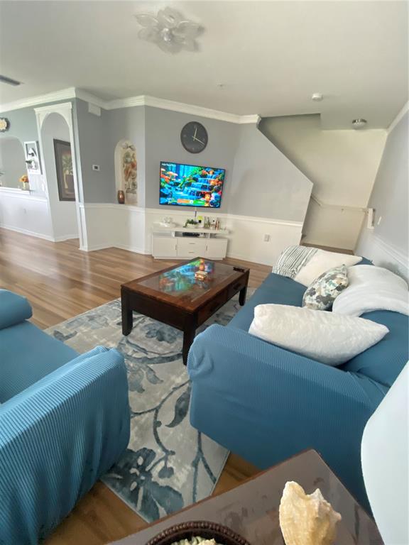 A living room features a blue sofa, a wooden coffee table, and a wall-mounted television — 3603 45TH TERRACE W UNIT 101, BRADENTON, FL