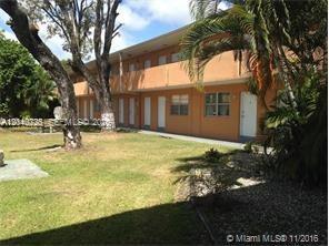 A two-story orange apartment building with exterior walkways sits behind a grassy lawn and trees — 9760 SW 184th St # 9A, Cutler Bay FL 33157, CUTLER BAY, FL