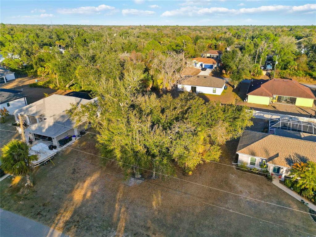 An aerial view shows houses surrounded by trees and a large, grassy yard — Lot 26 HOLLAND STREET, NORTH PORT, FL