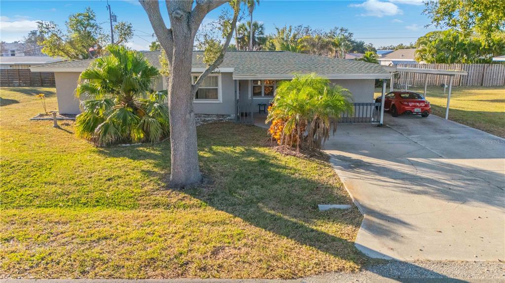 A single-story house with a gray exterior, a concrete driveway, and two palm trees — 524 SARABAY ROAD, OSPREY, FL
