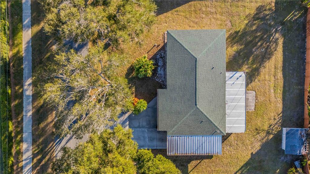 An aerial view shows a house with a green roof, a driveway, and surrounding trees — 524 SARABAY ROAD, OSPREY, FL