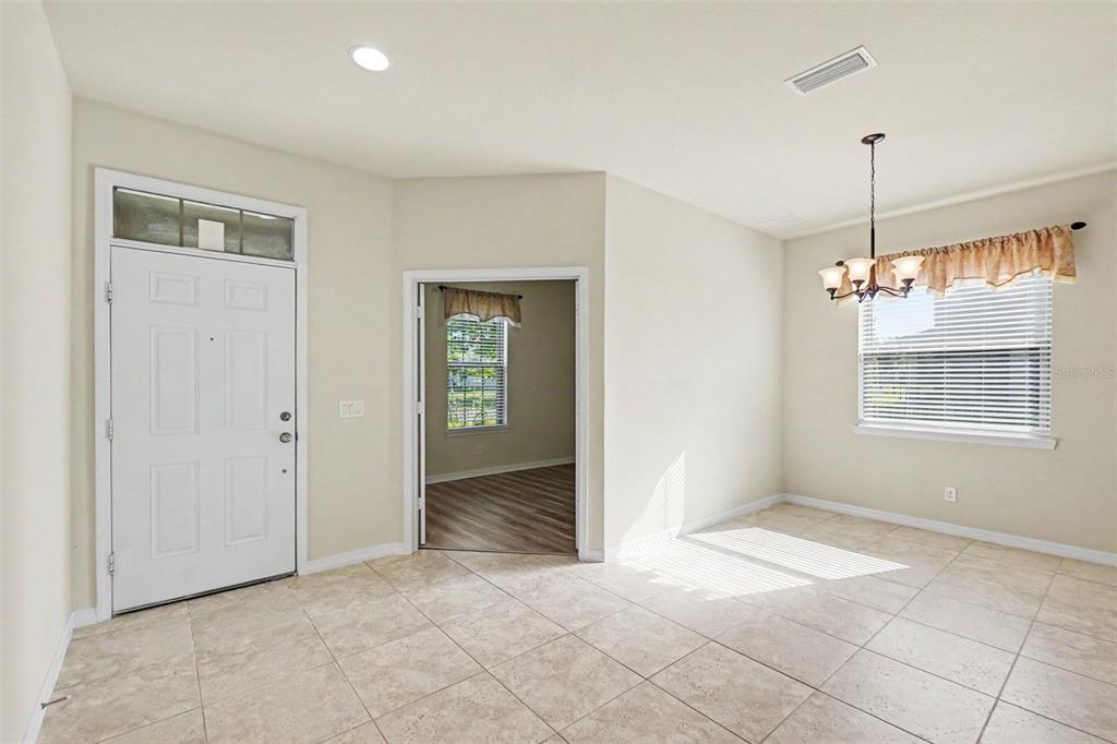 A dining area with tile flooring, a chandelier, and a doorway leading to another room — 9217 EUROPEAN OLIVE WAY, RIVERVIEW, FL