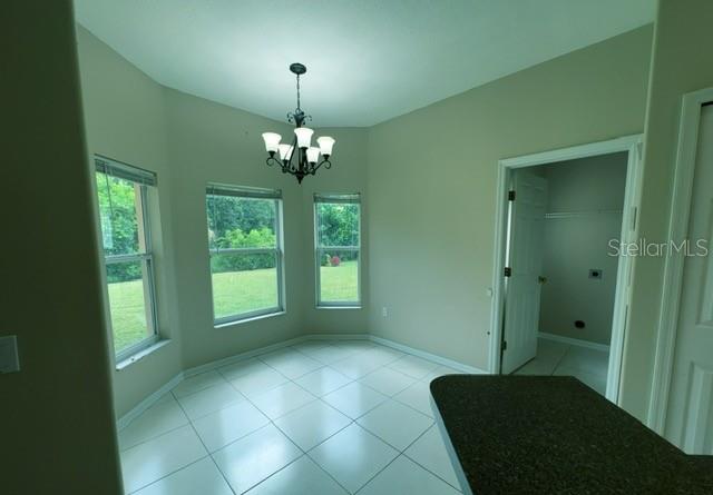 A dining area with tile floors, a chandelier, and windows overlooking a grassy yard — 3161 WINDING TRAIL, KISSIMMEE, FL
