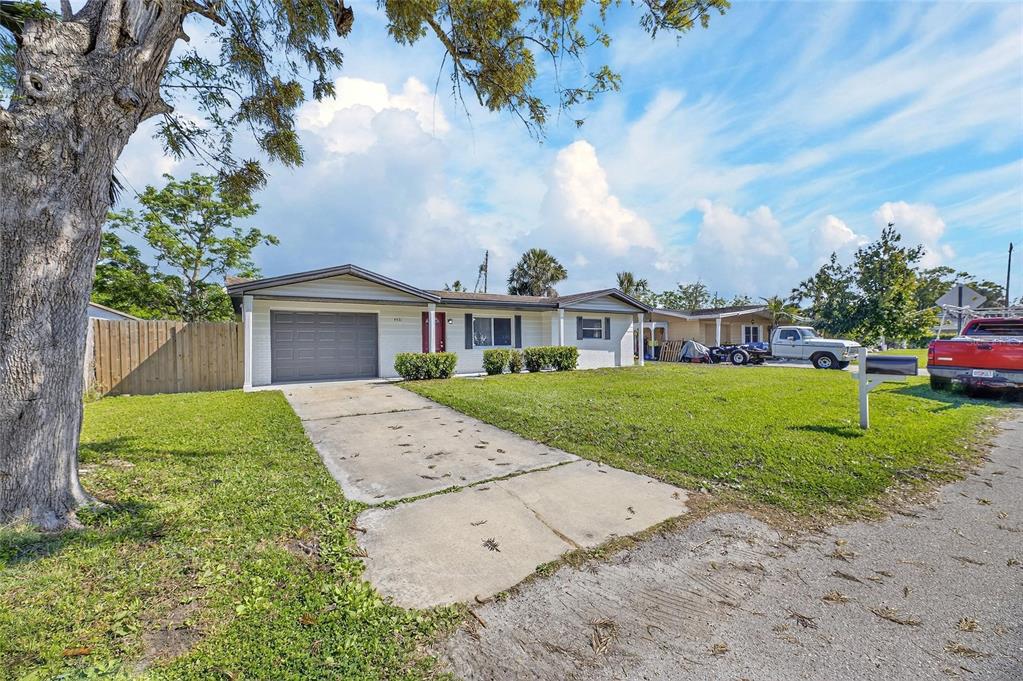 A single-story house with a gray garage door, white siding, and a concrete driveway — 4531 AEGEAN AVENUE, HOLIDAY, FL