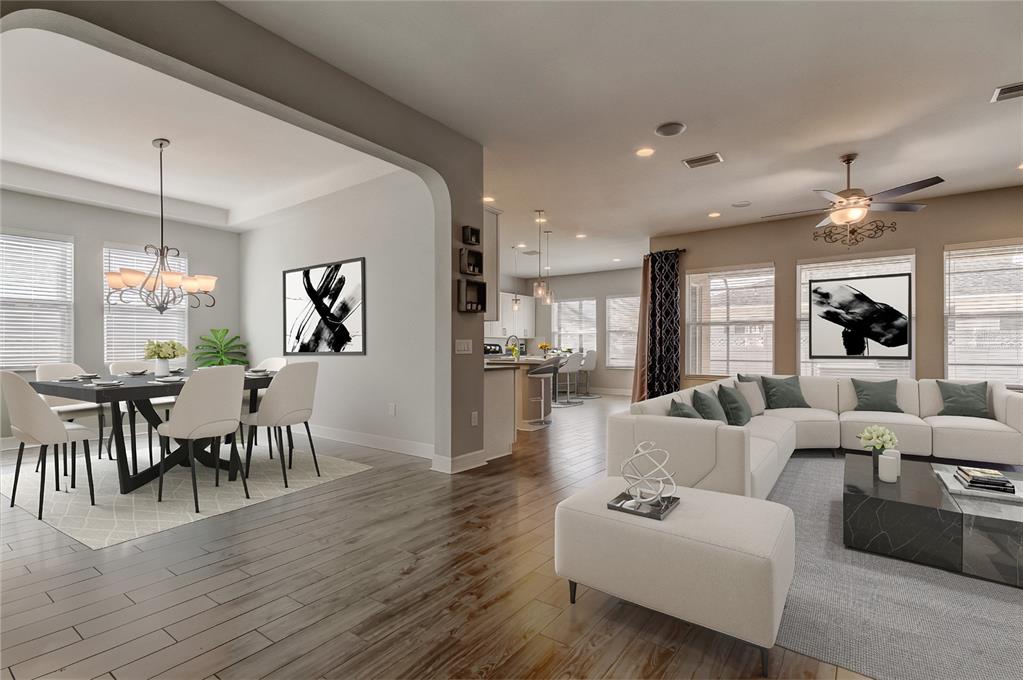An open-concept living and dining area features white furniture, dark wood flooring, and neutral walls — 33423 AZALEA RIDGE DRIVE, WESLEY CHAPEL, FL