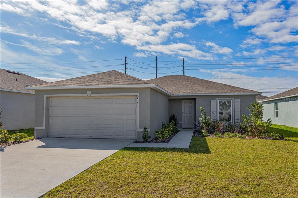 A single-story gray house with a two-car garage and a front walkway — 352 TOWNS CIRCLE, HAINES CITY, FL