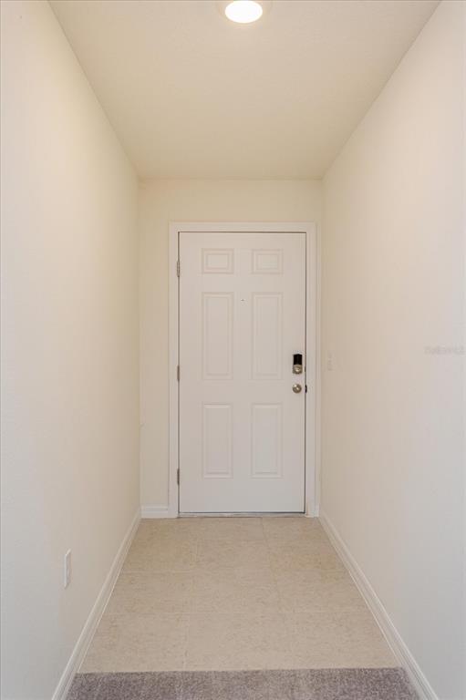 A narrow entryway features white walls, a tiled floor, and a white front door — 352 TOWNS CIRCLE, HAINES CITY, FL