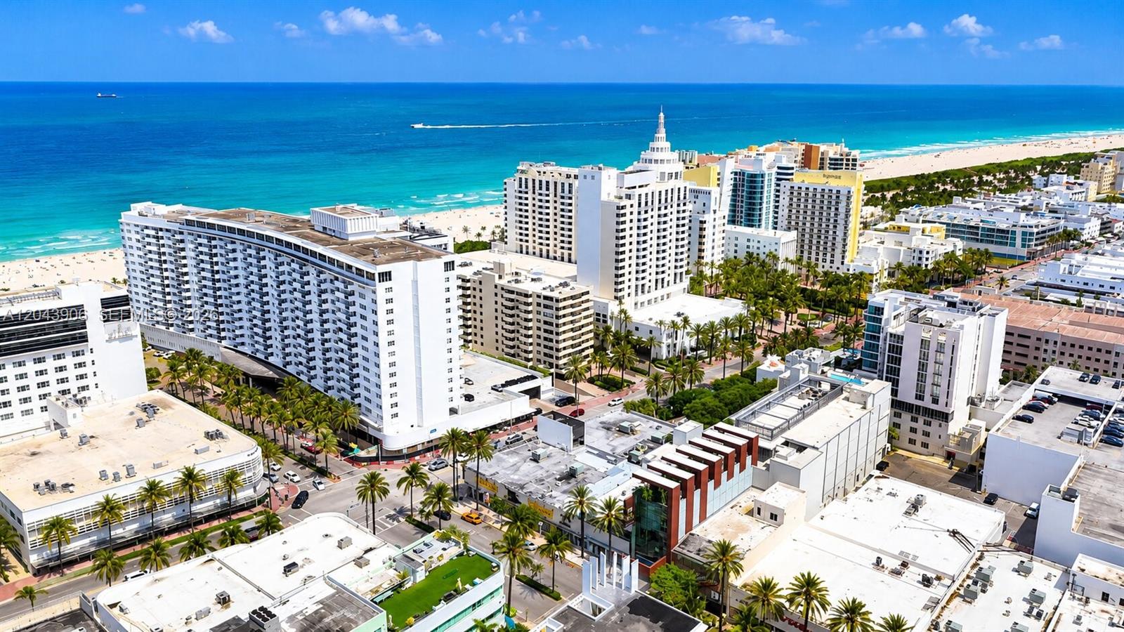 An aerial view of a coastal city featuring high-rise hotels, palm trees, and the ocean — 1623 Collins Ave # 415, Miami Beach FL 33139, MIAMI BEACH, FL