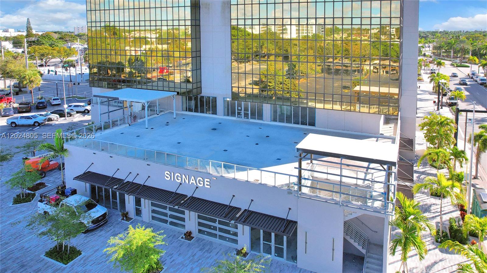 An exterior view of a modern commercial building with a flat roof and signage — 1909 Tyler St, Hollywood FL 33020, HOLLYWOOD, FL