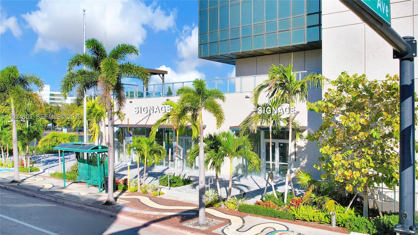 An exterior view of a commercial building with palm trees and a bus stop — 1909 Tyler St, Hollywood FL 33020, HOLLYWOOD, FL