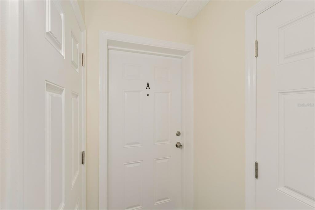 A hallway features three white doors, with the center door labeled with the letter A — 1062 85TH TERRACE N UNIT A, ST PETERSBURG, FL