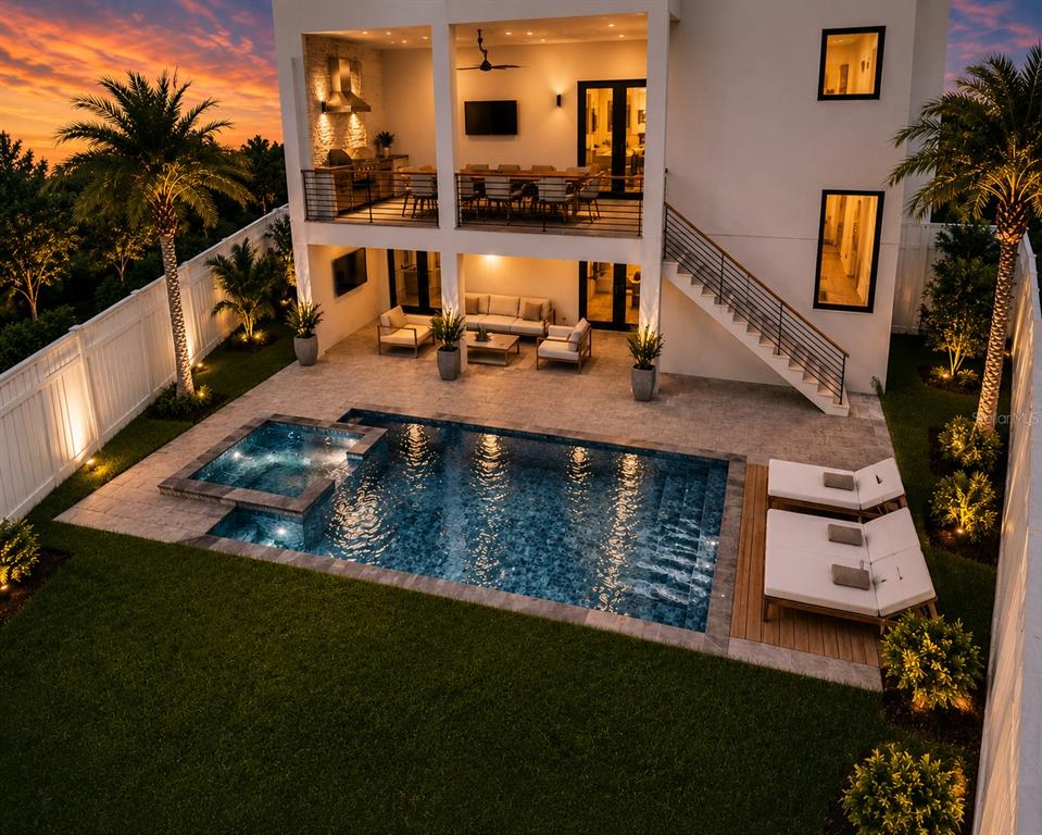 A two-story house with a pool, patio, outdoor kitchen, and staircase at sunset — 3406 BAYSHORE BLVD NE, ST PETERSBURG, FL