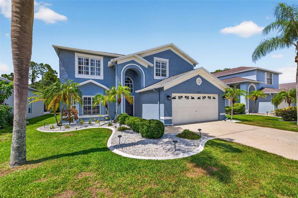 A two-story blue house with a white garage and a landscaped front yard — 11123 CLAYRIDGE DRIVE, TAMPA, FL