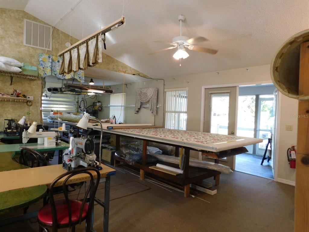 A sewing or craft room features a large work table, sewing machines, and ceiling fan — 4655 N CARL G. ROSE HIGHWAY, HERNANDO, FL