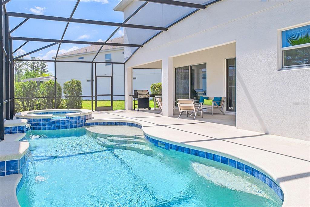 A swimming pool and spa with a screened-in patio and outdoor grill area — 2560 SHANTI DRIVE, KISSIMMEE, FL