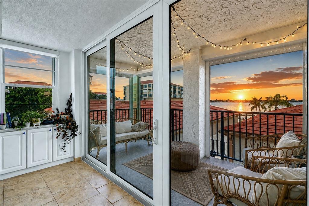A sunroom with tile floors and glass sliding doors opens to a balcony overlooking water — 6145 SUN BOULEVARD UNIT 306, ST PETERSBURG, FL